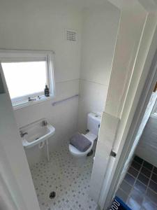 a bathroom with a toilet and a sink and a window at Rear studio with open space in Sydney