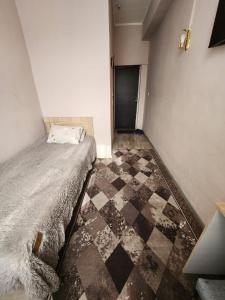a bedroom with a bed and a checkered floor at Оазис in Almaty