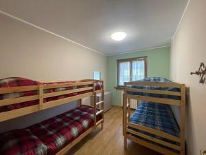 a bedroom with two bunk beds and a window at Villa Glory Mountain Lake Iseo Hospitality in Bossico