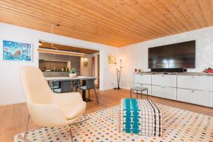 a living room with a table and a kitchen at Backcountry Hotel*Super Premium in Disentis