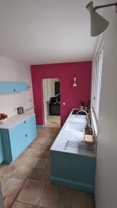 uma cozinha com um lavatório branco e paredes vermelhas em Villa de charme avec Jardin dans Saint Martin Intramuros em Saint-Martin-de-Ré