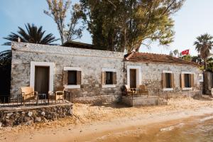 a house on the beach with chairs in front of it at Flamm in Golturkbuku