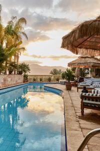una piscina in un resort con sedie e ombrelloni di Villa Balfour a Eilat