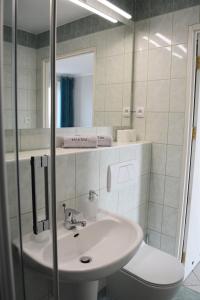 a bathroom with a sink and a toilet and a mirror at Apartament Martini in Kołobrzeg