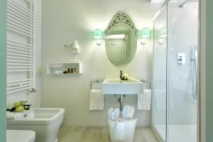 a bathroom with a sink and a toilet and a mirror at Aquamare, boutique b&b in Venice