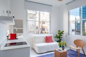 sala de estar blanca con sofá blanco y ventanas en Isla apartment's, en Tel Aviv