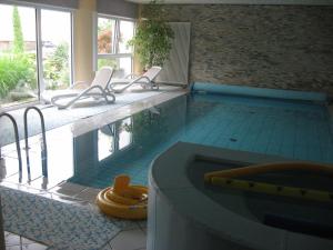a large swimming pool with chairs and a tub at Pension Chalet Andy in Schenna