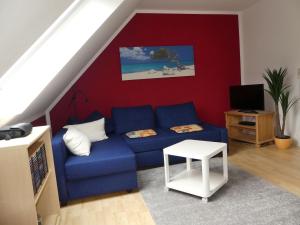 sala de estar con sofá azul y pared roja en Bramwaldblick, en Hannoversch Münden