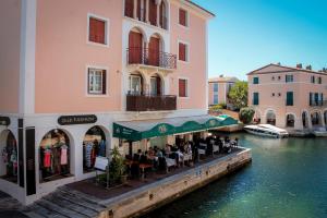 un ristorante sul lato di un edificio accanto a un fiume di COSY TROPEZ, la petite Venise, Port-grimaud a Grimaud