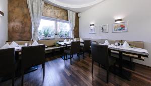 a dining room with tables and chairs and a window at Haus Fabry in Hilden