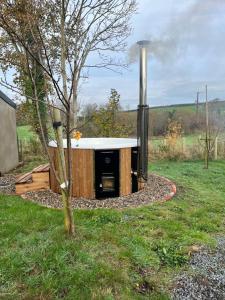 Bramble Cottage في Rathfriland: حوض استحمام ساخن في الهواء الطلق مع موقد في الفناء