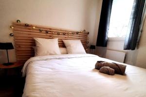 - une chambre dotée d'un lit blanc avec un animal rembourré dans l'établissement Dolce vita en centre ville, à Niort