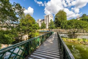 un puente sobre un río con un edificio al fondo en Dolce vita en centre ville, en Niort