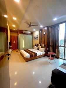a bedroom with a bed and a large window at AVIRAHI HOTEL in Mumbai