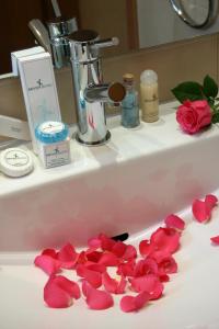 a bathroom sink with rose petals on it at Deves Hotel in Nafplio