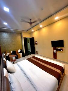 a bedroom with a large bed and a couch at AVIRAHI HOTEL in Mumbai