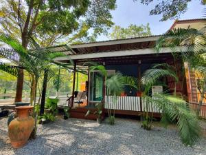 a house with a large vase in front of it at Bansuanrimnam Pakchong Resort in Pak Chong