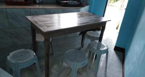 a wooden table with four stools in a kitchen at CBHaus in El Nido