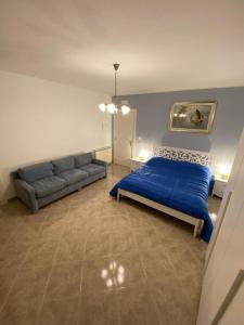 a bedroom with a blue bed and a couch at Residenze BepiLù in Bari