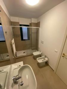 bagno con lavandino, servizi igienici e specchio di Residenze BepiLù a Bari