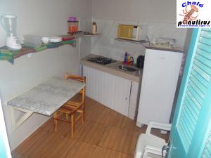 eine kleine Küche mit einem Tisch und einem Kühlschrank in der Unterkunft Chalé Panulirus in Icapuí