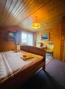 ein Schlafzimmer mit einem großen Bett in einem Holzzimmer in der Unterkunft Pension Grizzly in Ludvíkov