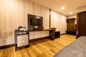 a hotel room with a bed and a television at Sandbanks Beach Villas, Morjim in Morjim