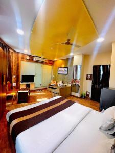 ein Schlafzimmer mit einem großen Bett mit gelber Decke in der Unterkunft AVIRAHI HOTEL in Mumbai
