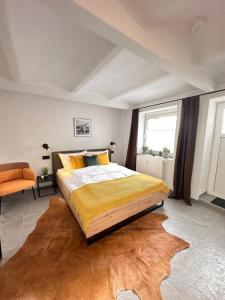 1 dormitorio con 1 cama grande y 1 silla naranja en Appartement Auhagen - Küche, Badewanne, Regendusche, Netflix, en Auhagen