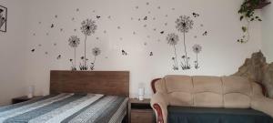 a bedroom with a bed and dandelions on the wall at Lugas Apartman in Tapolca
