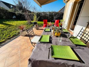 - une table avec des serviettes vertes et des verres à vin sur la terrasse dans l'établissement Maison au Mans, 6 pièces, 8 personnes, au Mans