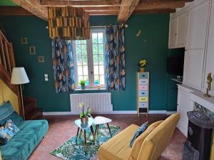 - un salon avec des murs verts et un canapé dans l'établissement La maison des animaux de compagnie, à Grumesnil