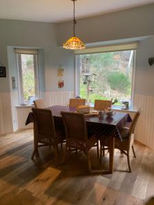 ein Esszimmer mit einem Tisch, Stühlen und einem Fenster in der Unterkunft Amazing cottage with private indoor swim pool and hot tub in Grantown on Spey
