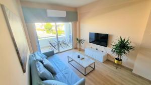 a living room with a blue couch and a tv at The Urban Oasis - Comfort 2br near the City Center, 200Mbit Internet and Smart TV in Larnaca