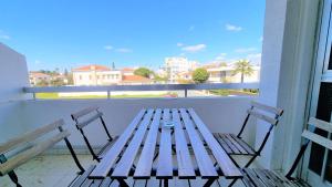 a wooden bench sitting on a balcony with two chairs at The Urban Oasis - Comfort 2br near the City Center, 200Mbit Internet and Smart TV in Larnaca