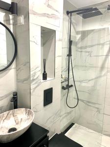 ein Bad mit einem Waschbecken und einer Dusche in der Unterkunft Asitad DeLuxe Apartments in Ruse