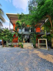 Casa grande con balcón y árboles frente a ella en Bansuanrimnam Pakchong Resort, en Pak Chong