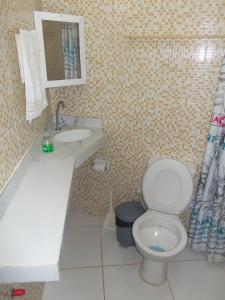 ein Bad mit einem WC und einem Waschbecken in der Unterkunft Chalé Panulirus in Icapuí