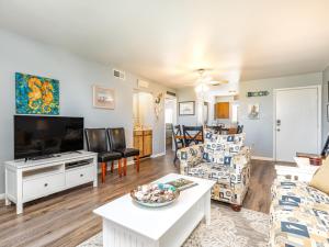 a living room with a couch and a tv at Lighthouse Point 20A in Tybee Island