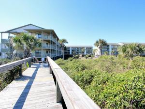 a wooden boardwalk leading to a building on the beach at Lighthouse Point 20A in Tybee Island