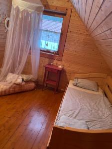 Zimmer im Dachgeschoss mit einem Bett und einem Fenster in der Unterkunft Chata Lišiačik in Tajov
