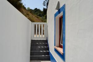 una escalera que conduce a una casa con toques azules en Casa do Vale - Valley House, en Odeceixe