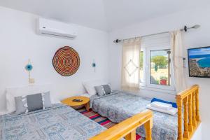 a bedroom with two beds and a window at Cavo Prima Kiotari in Gennadi