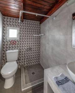 a bathroom with a toilet and a sink at Cavo Prima Kiotari in Gennadi