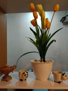 a vase with yellow flowers in it on a shelf at D'Ariska Rooms Homestay in Jombang