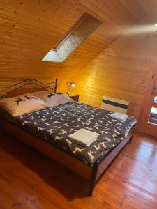 a bedroom with a bed in a wooden room at Chata Lišiačik in Tajov