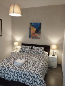 ein Schlafzimmer mit einem Bett mit zwei Nachttischen und zwei Lampen in der Unterkunft Day Ok Beach Apartment in Malgrat de Mar