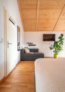 1 dormitorio con 1 cama y 1 sofá en Swiss Alps View Apartment - contactless self check-in, en Thun