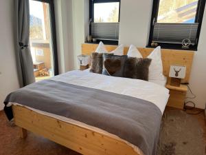 a bedroom with a large wooden bed with pillows at Bergchalet Stolzalpe in Stolzalpe +14 photos