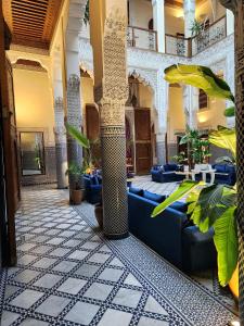 un vestíbulo de un hotel con muebles y plantas azules en Le Riad Palais d'hotes Suites & Spa Fes, en Fez